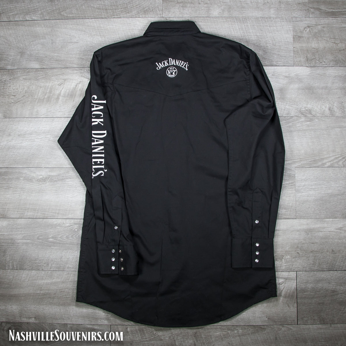 Jack Daniels officially licensed long sleeve black Western Rodeo Shirt featuring a large, bright white embroidered Jack Daniels logo on one sleeve along with the swing and cartouche label embroidered on the front left chest area.