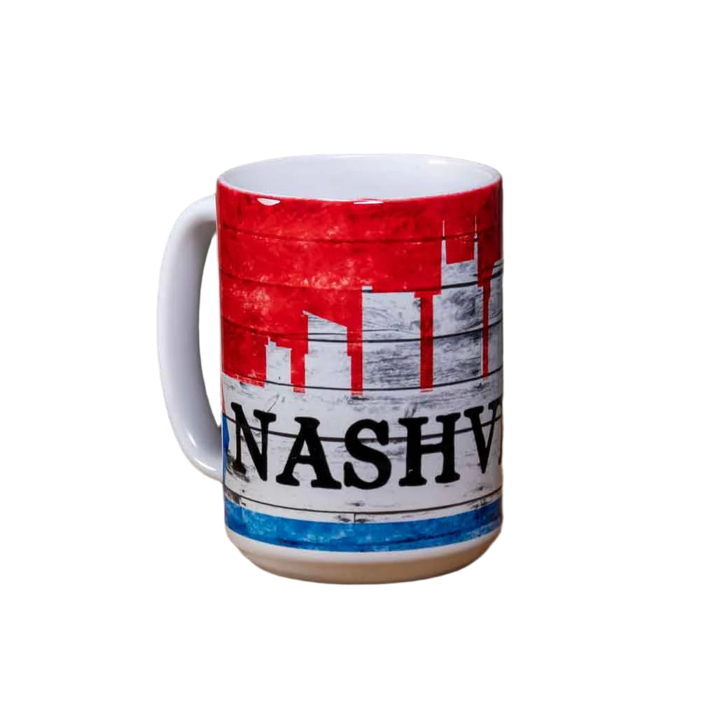 This "Nashville Skyline" Coffee Mug is a white ceramic mug with an easy to grip handle. The mug features a simple, yet attractive Nashville skyline design in red, white and blue. A big bold "Nashville" is printed in black.