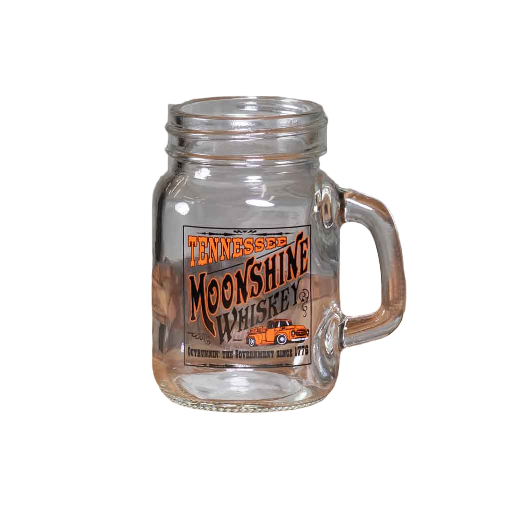 A new, oversized Tennessee "Moonshine Whiskey "Shot Glass printed with a rectangular logo featuring a moonshiners truck and "outrunnin' the government since 1779".