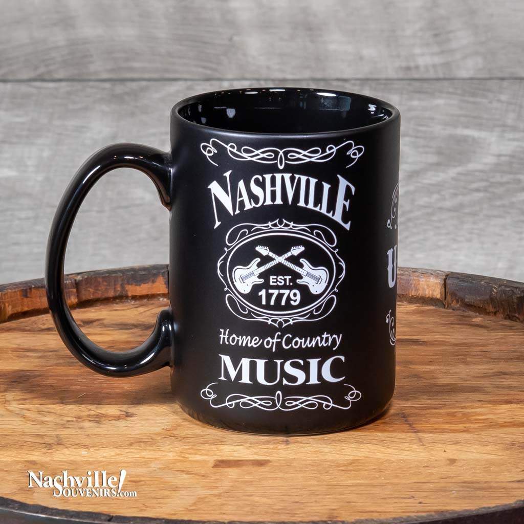 Left side view of a great new Nashville "Home of Country Music" Mug design that is big and easy to grip. This mug design features a prominent Nashville with crossed guitars and "Home of Country Music" below. The white on black design is inspired by our famous Tennessee Whiskey.