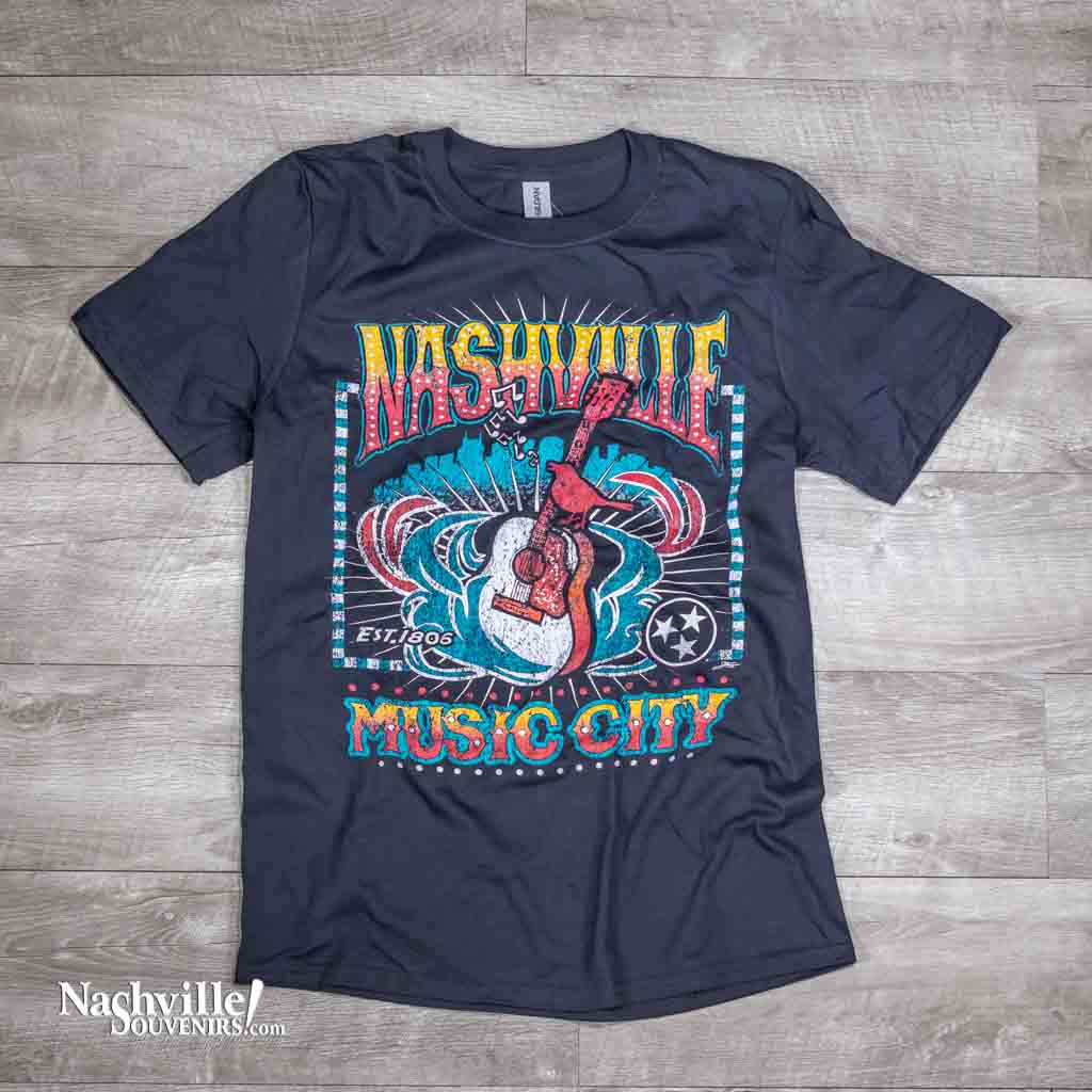 Nashville "Guitar Bird" T-shirt features a very colorful logo highlighted by a bird sitting on the neck of an acoustic guitar. Above that is a big, bold Nashville with Music City below.