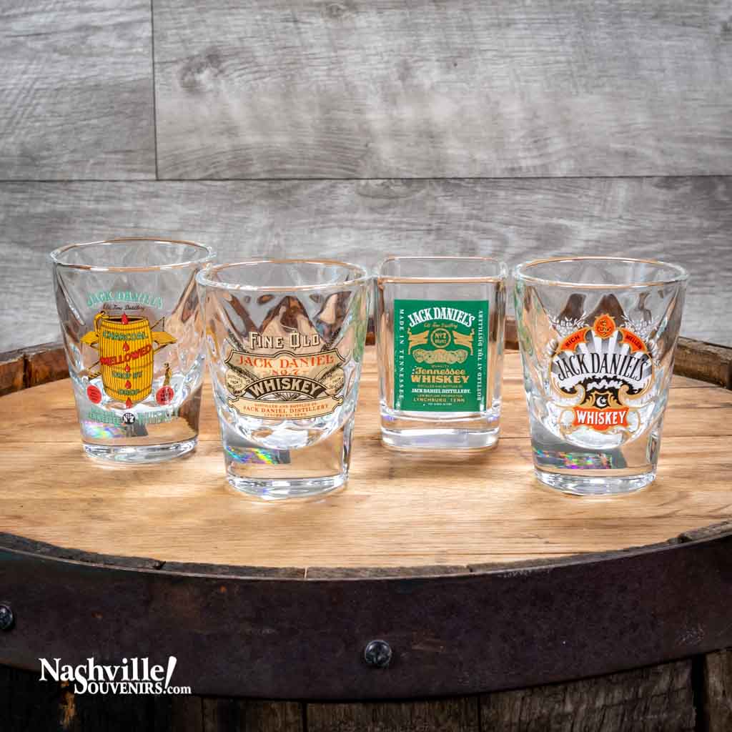 A set of four vintage collectible JacK Daniel shot glasses. Four different vintage JD logos including, the Charcoal Mellowed, Fine Old Whiskey, Green Label and Spade designs.