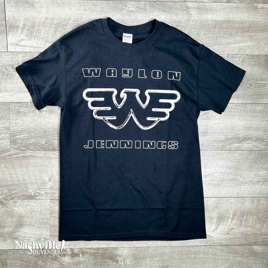 This Waylon Jennings T shirt with Flying W Logo featuring a simple but effective design. It says simply, "Waylon" above the flying W logo and "Jennings" beneath it. The lettering is white on a black shirt. It is made from 100% pre-shrunk cotton. This shirt comes in sizes Small to 3X.