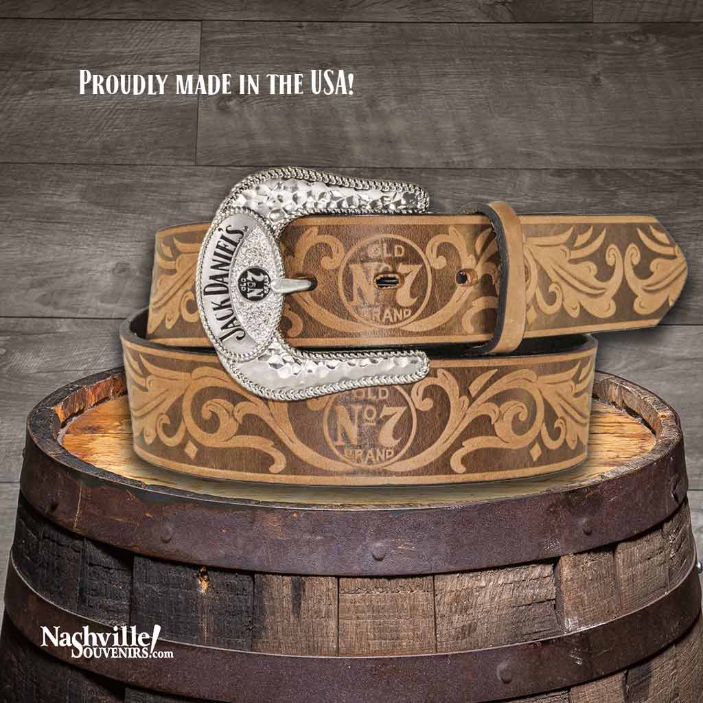 Tan colored Jack Daniel's branded belt that is 1 1/2" wide with an embossed filigree weave and made from full grain leather. The buckle is silver plated featuring the Jack Daniel's Swing and bug logo in black against a hammered silver background.