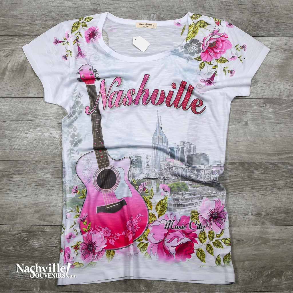 Ladies Nashville shirt featuring the Nashville skyline along with an acoustic guitar and big Nashville logo.