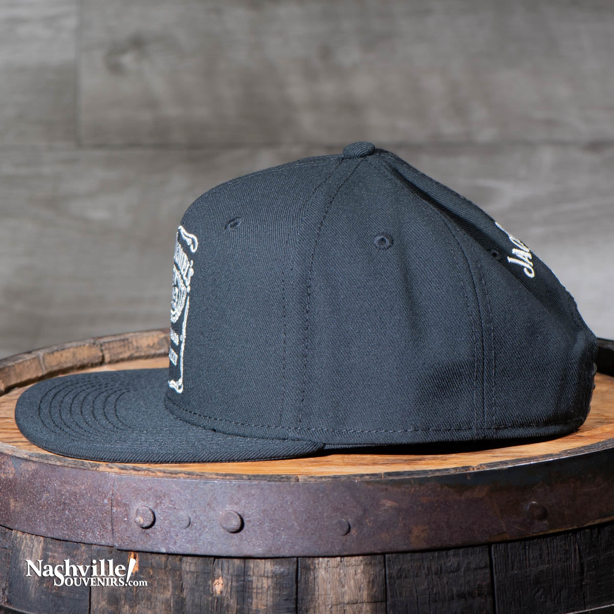 Side view of a Jack Daniel's flatbrim hat has the classic Jack Daniel's bottle label logo embroidered on the front crown. Turn it around and you'll find another embroidered Jack Daniel's swing and bug logo above the snap back closure.