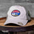 This Nashville Music City Cap features an oval patch with an embroidered Guitar and Nashville Music City stitched on a colored background.  The Nashville hat has a stiff, rounded khaki colored bill in a relaxed fit vintage washed twill and a cloth front crown. The body has two matching front khaki panels and the remainder are in a darker olive green color.