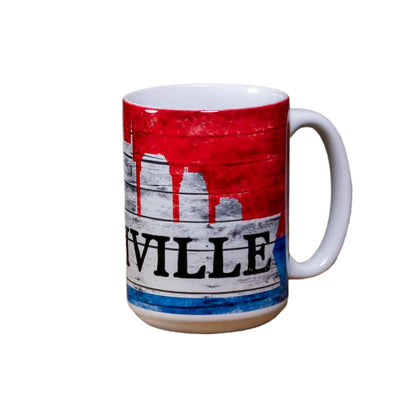 This "Nashville Skyline" Coffee Mug is a white ceramic mug with an easy to grip handle. The mug features a simple, yet attractive Nashville skyline design in red, white and blue. A big bold "Nashville" is printed in black. 