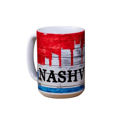 This "Nashville Skyline" Coffee Mug is a white ceramic mug with an easy to grip handle. The mug features a simple, yet attractive Nashville skyline design in red, white and blue. A big bold "Nashville" is printed in black. 