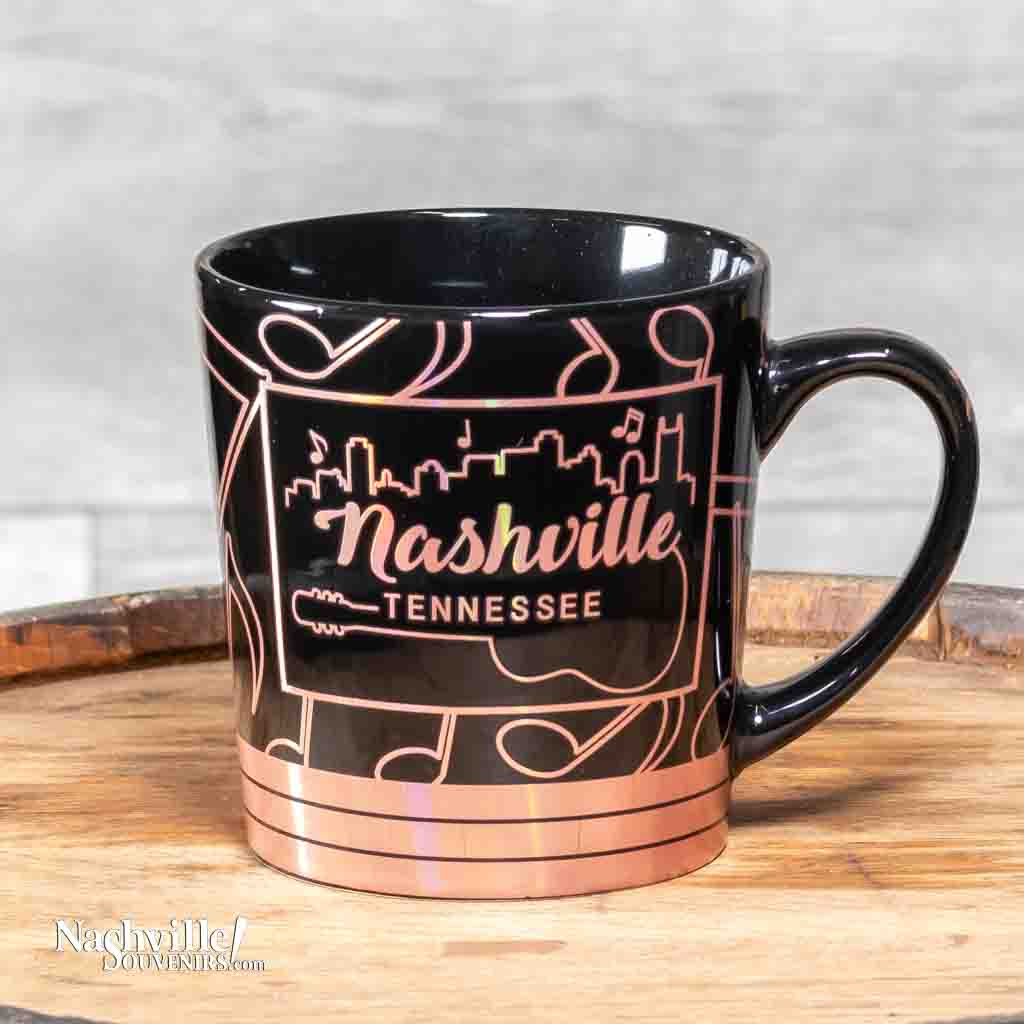 This oversize Nashville Music Notes Coffee Mug has an easy to grip handle and is made from a glossy black ceramic material. The wide mouth mug features a wrap around design of gold reflective music notes along with the Nashville skyline.