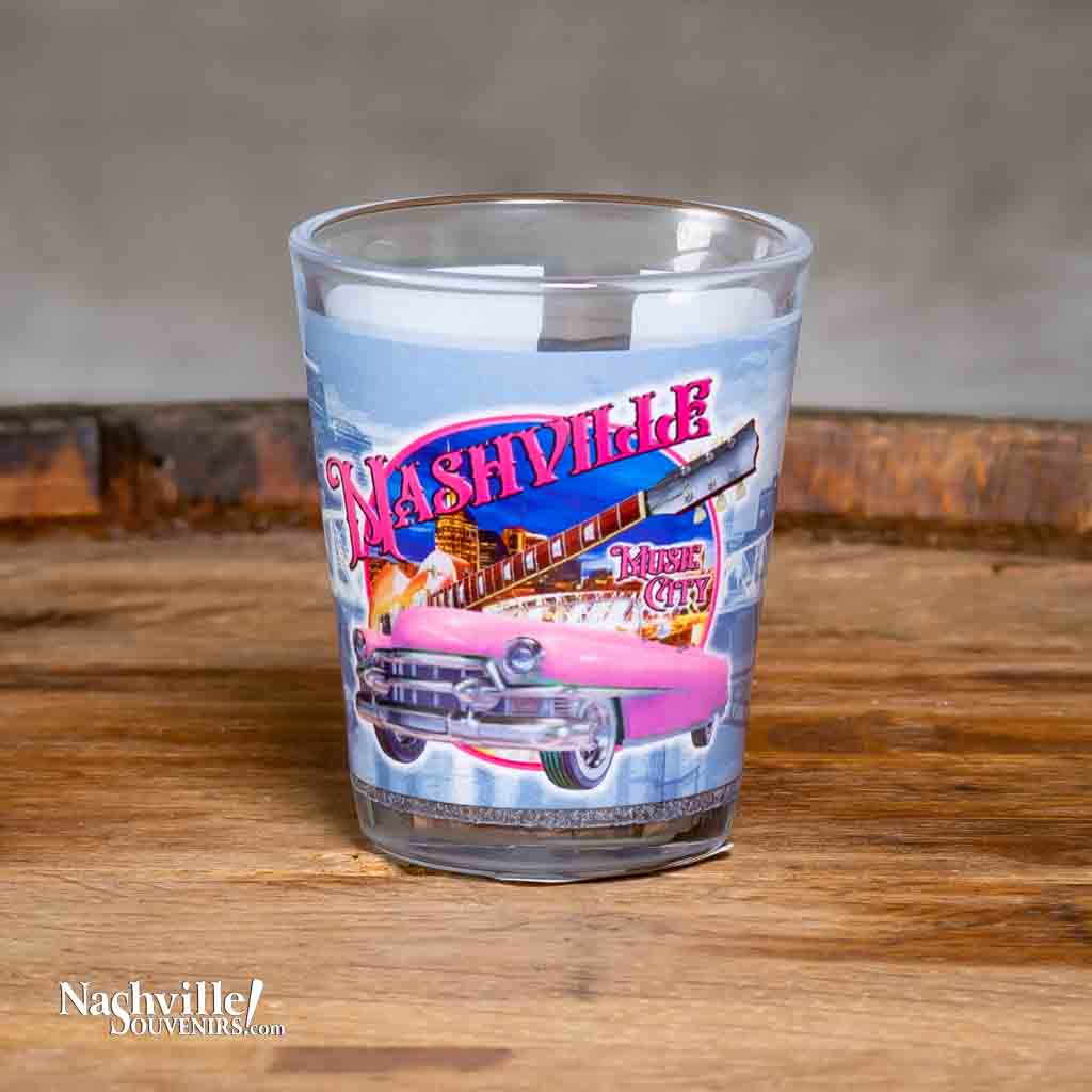 A new Nashville Pink Cadillac Shot Glass printed with a colorful and scenic design incorporating a pink Cadillac, Guitar and downtown Nashville.