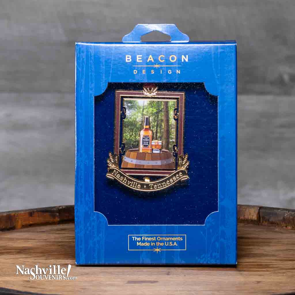 This Tennessee Whiskey Collectible Ornament will be a great addition to any collection. It contains a forest scene behind a bottle of whiskey sitting atop an oak barrel. Below the whiskey is "Nashville Tennessee" etched on a gold banner.