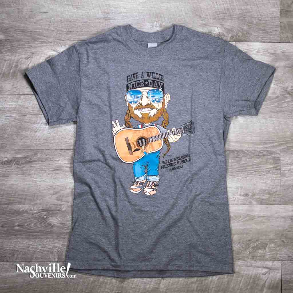 The very popular, Have a Willie Nice Day t-shirt featuring an image of Willie Nelson playing his guitar and wearing sunglasses. He is also wearing a "Have a Willie Nice Day" bandana. 