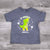 Our kids "T-Rocks" Nashville T-shirt has been a big hit here in our store. It features a guitar playing T-Rex dinosaur in a colorful green and yellow logo design. The T-Rex is surrounded by white stars and music notes with "Nashville" printed below. Gray body color.
