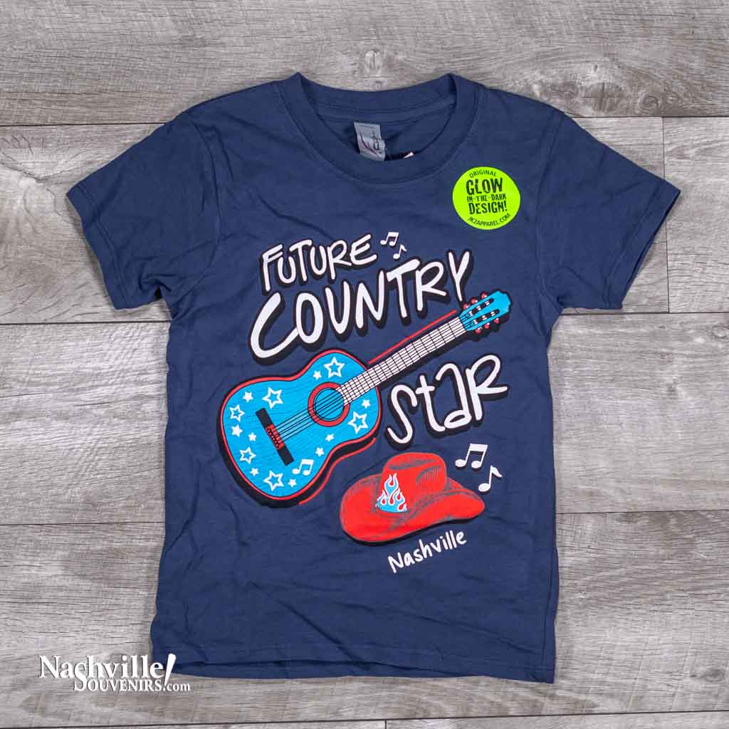 A great new glow in the dark design featuring a big bold blue and red guitar and Cowboy hat. Along with those images, printed in big letters are the words "Future Country Star Nashville" in blue color.