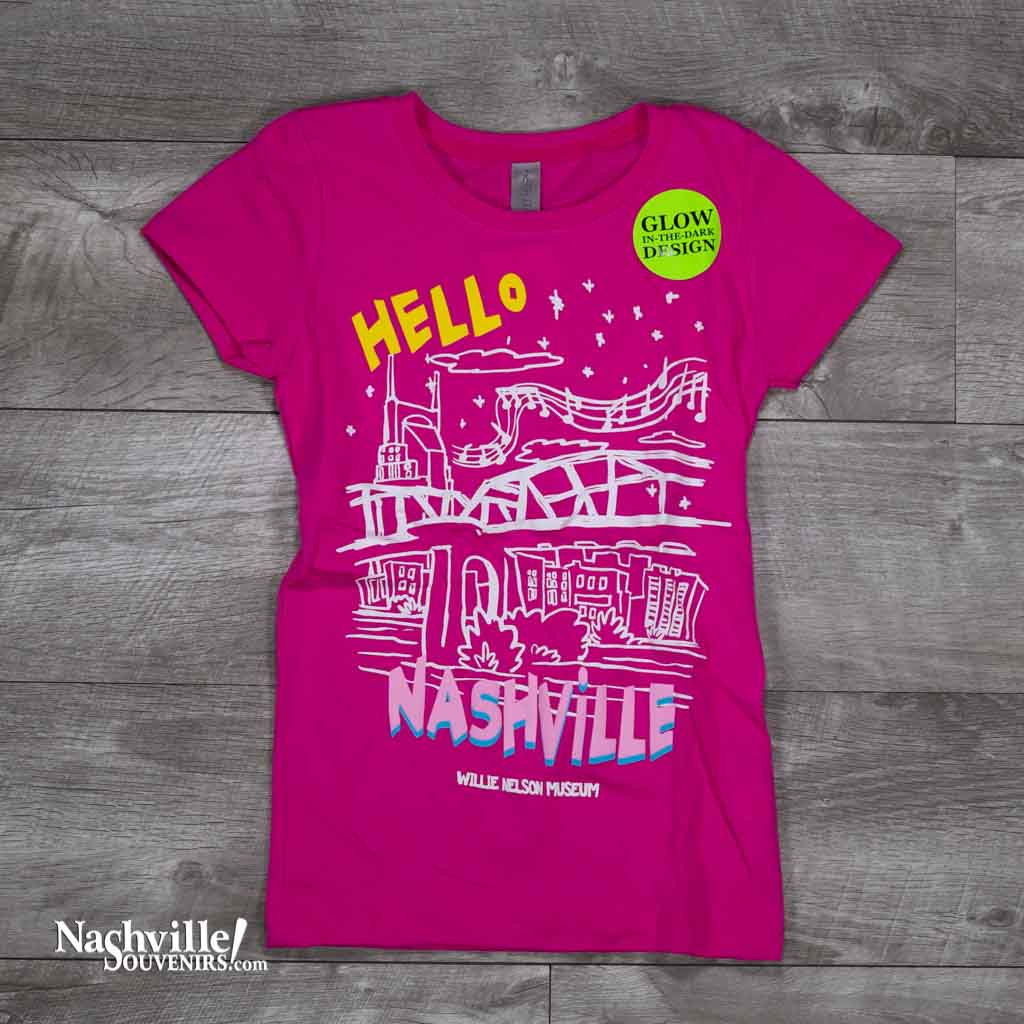 kids pink colored Hello Nashville Youth T-Shirt features a colorful glow-in-the-dark logo with the Nashville skyline and Willie Nelson Museum at the bottom of the t-shirt.