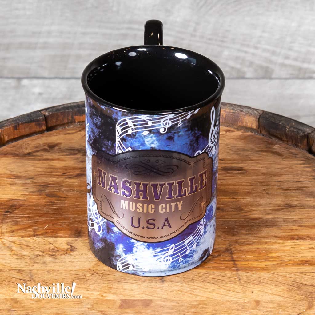 Side view of a great new Nashville Music City USA Mug design that is big and easy to grip. The handle features a large handle with a music note design.  The body of the mug has an intricate design featuring music notes, cowboy boots and guitars. 