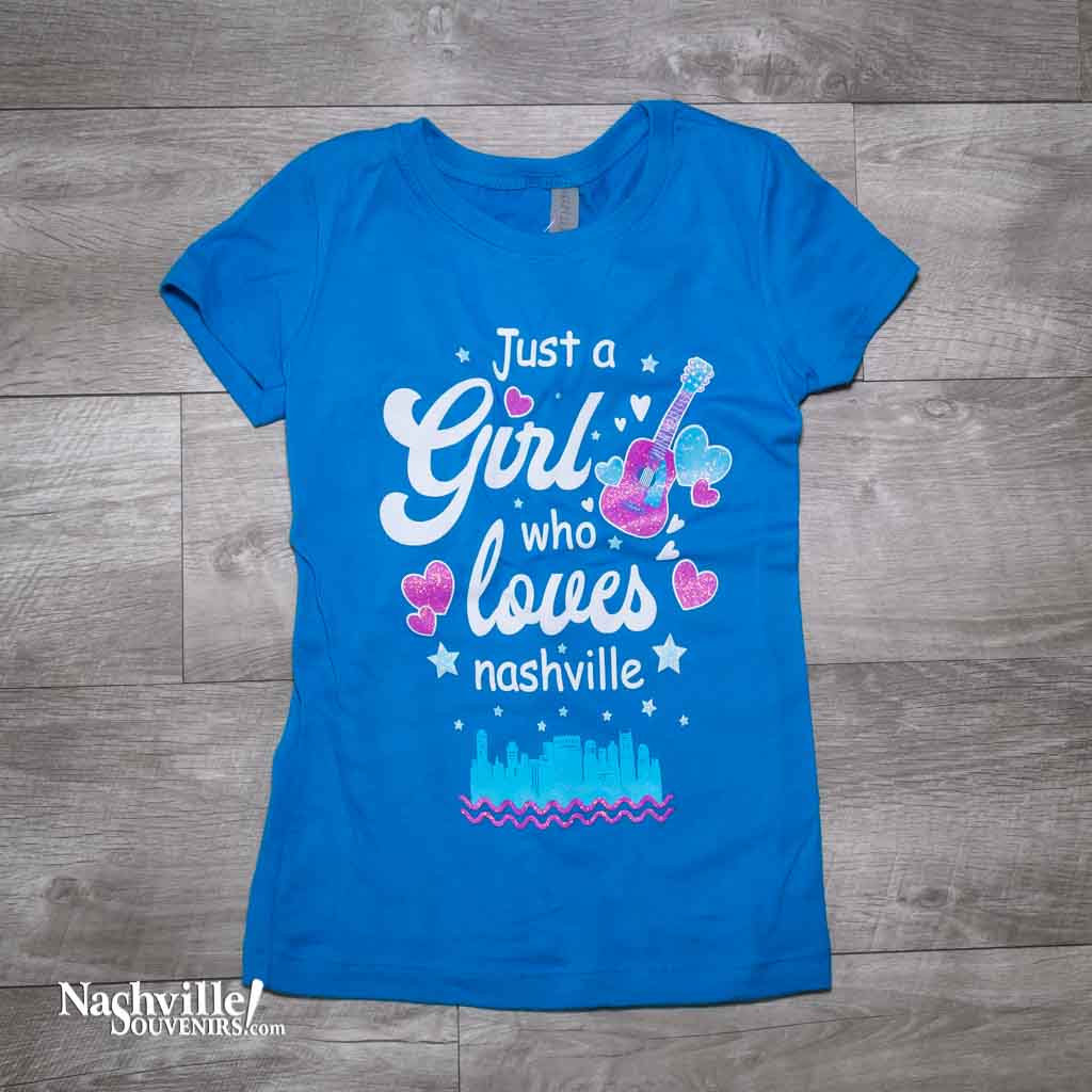 Our new design "Just A Girl Who Loves Nashville" T-Shirt features a colorful logo that includes the Nashville downtown skyline and guitar and hearts.  This shirt is available in either Turquoise or Silk and comes in youth sizes X-Small, Small, Medium and Large.