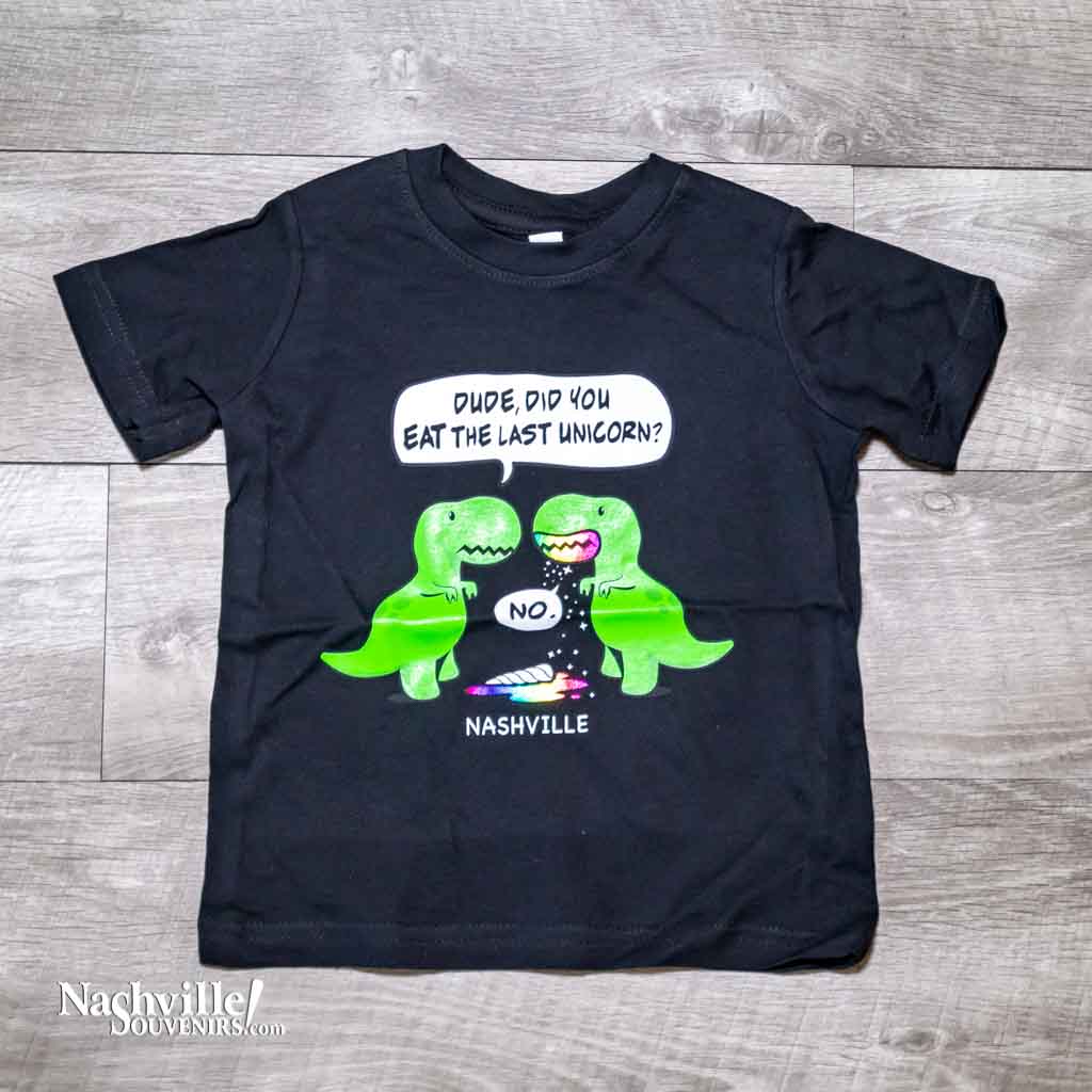 Black toddler "Last Unicorn Nashville" T-Shirt features a colorful logo that includes two dinosaurs discussing the mysterious demise of the last unicorn! Beneath the dinosaurs you'll find "Nashville".