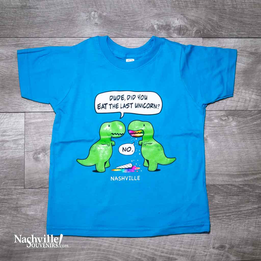 Turquoise toddler "Last Unicorn Nashville" T-Shirt features a colorful logo that includes two dinosaurs discussing the mysterious demise of the last unicorn! Beneath the dinosaurs you'll find "Nashville".