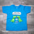 Turquoise toddler "Last Unicorn Nashville" T-Shirt features a colorful logo that includes two dinosaurs discussing the mysterious demise of the last unicorn! Beneath the dinosaurs you'll find "Nashville".